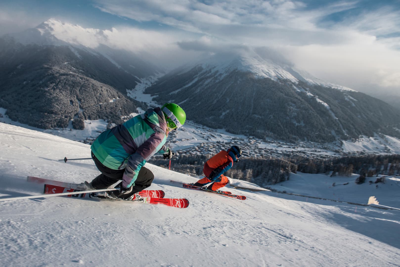 Couple of skiers skiing down piste in Davos ski resort on a Switzerland ski holiday
